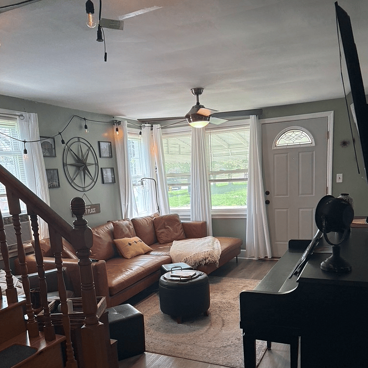 living room with big screen Smart TV above standing piano (Netflix provided; all other apps available for login)