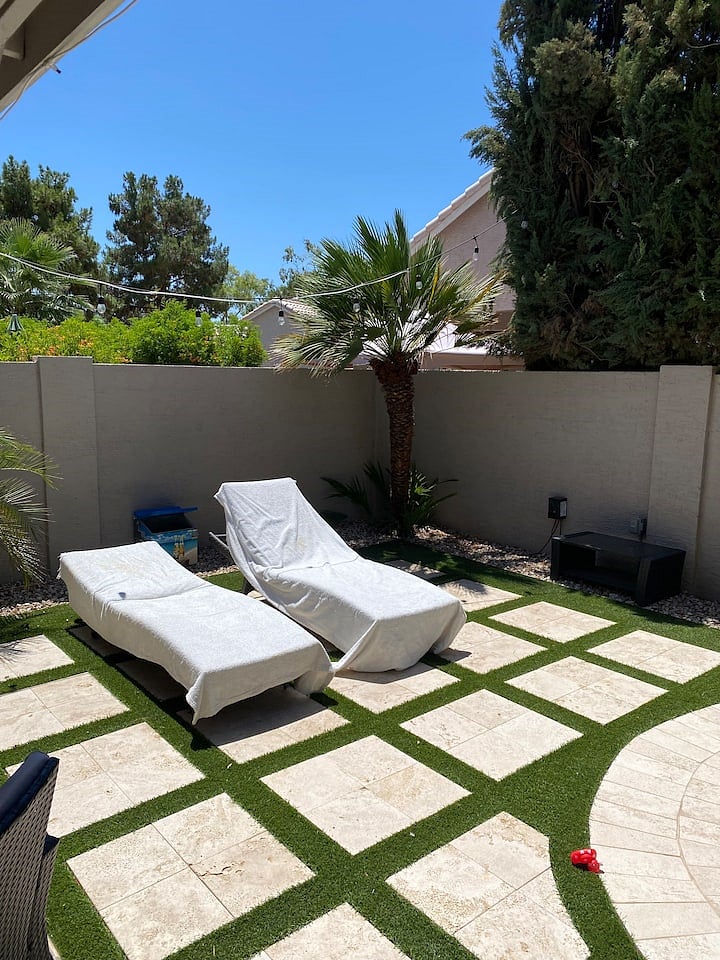 Backyard is travertine and turf.