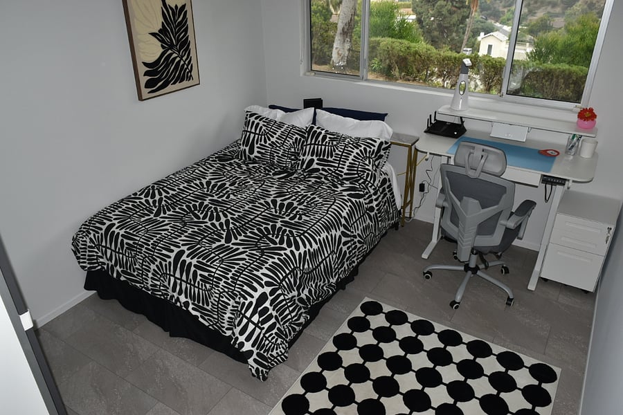 South facing bedroom. Nectar foam mattress, queen, electric standing desk with view of yard. Closet with shelves and drawers. Matching art to comforter and rug. Solar blinds. Console behind bed. 