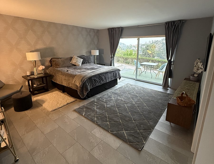 Master bedroom with king size hybrid mattress, linens, comforter, rugs, console, Samsung Fram TV. ADJUSTABLE FRAME BED. Reading chair, light, bar cart.