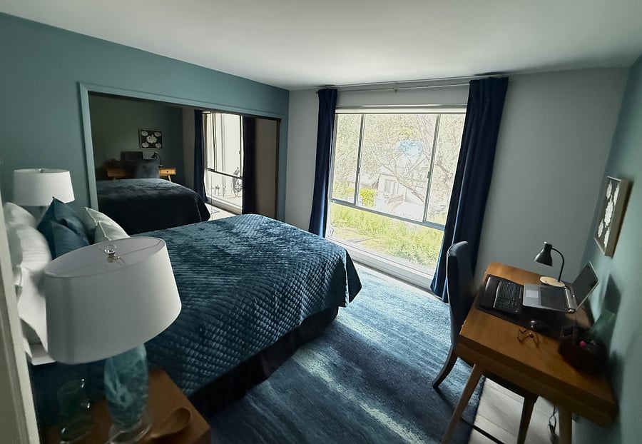 North facing bedroom. Desk with lamp. Bronzed mirror closet doors. Inside drawers and shelves in closet. Queen hybrid mattress, new, with ADJUSTABLE frame bed with zero gravity option. Solar blinds and blackout curtains for complete darkness.  View of front yard, olive tree and lavendar. 