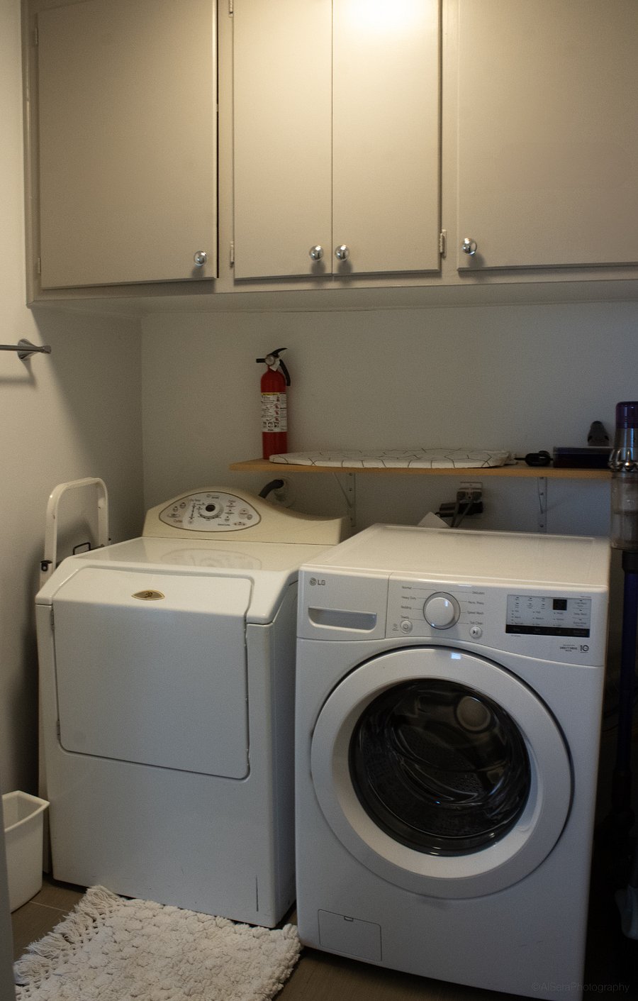 LG washer, Maytag dryer, Ironing Board, Dyson Vacuum, Cleaning supplies in cabinets