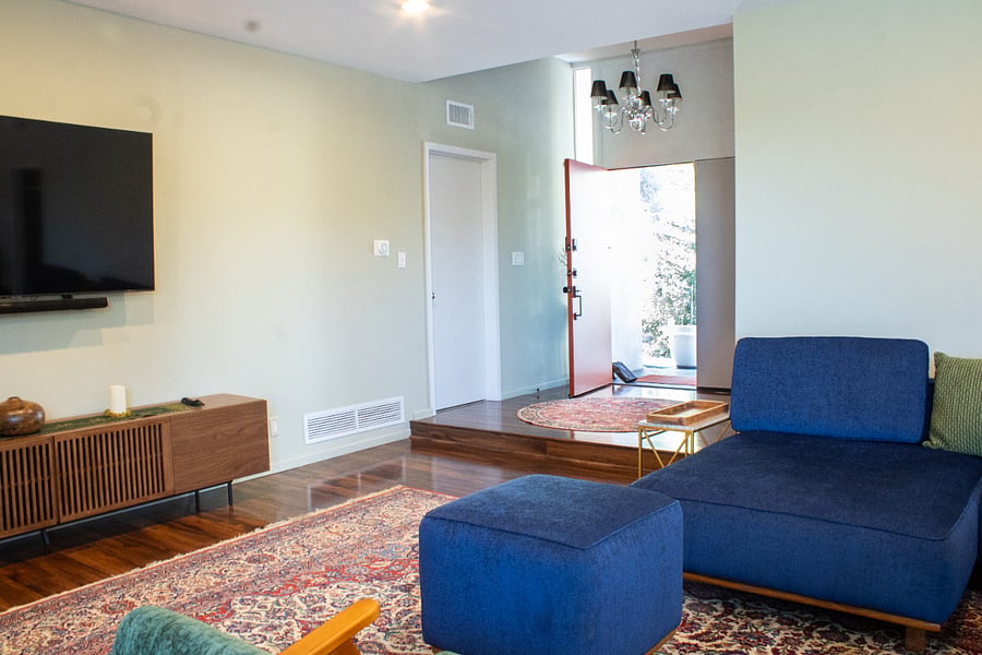 Foyer entry, into living room. Wall mounted TV with sound bar and subwoofer. 70 inchesSouth