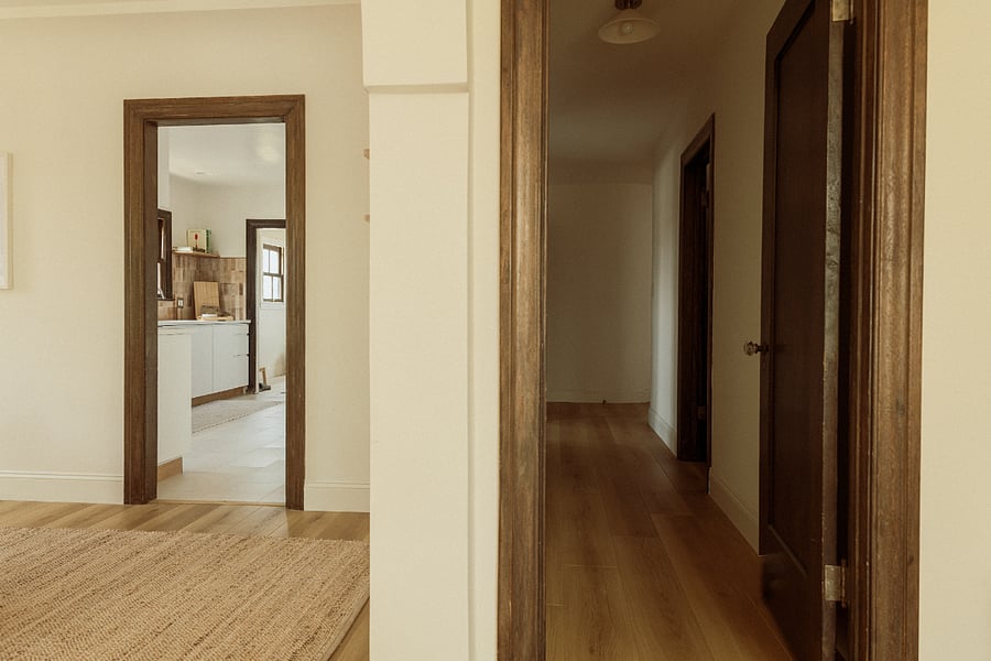 From the living room, the dining area is located to the left and flows seamlessly into the kitchen. To the right, a hallway leads to the bedrooms and bathrooms while also providing another convenient connection to the kitchen, creating an easy and functional layout throughout the home.