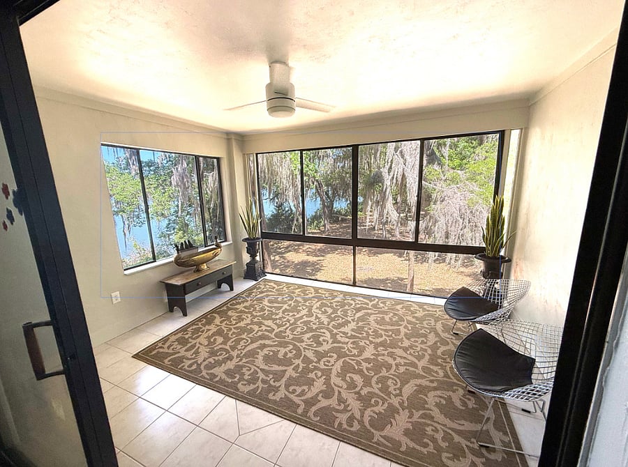Sunroom featuring tree canopy & lake views