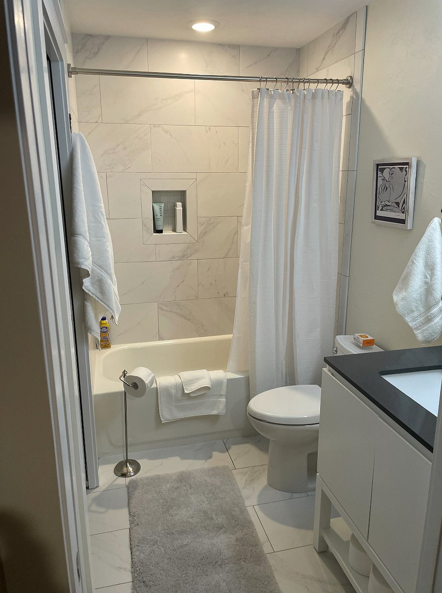 Bathroom featuring simulated marble shower walls & flooring