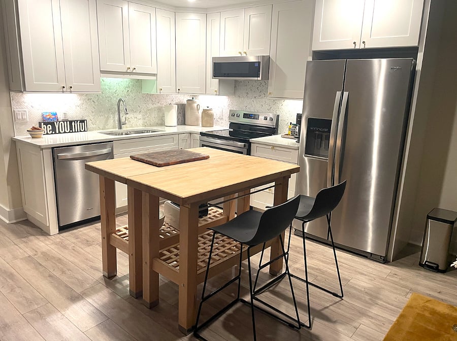 Kitchen layout, including bright white cupboards & butcher block island