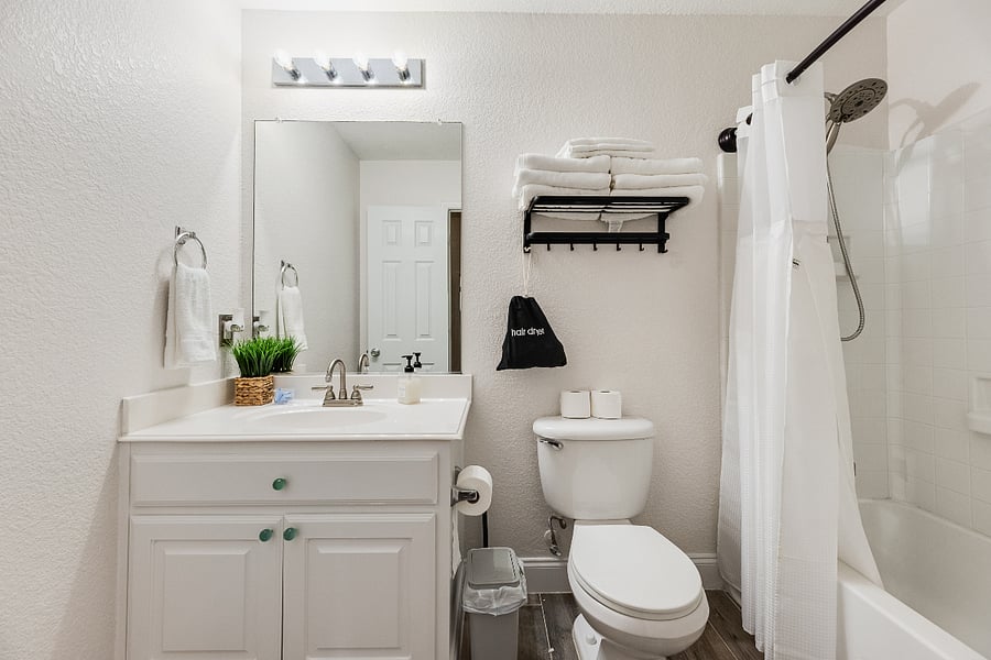 Comfortable guest bathroom with shower, built-in soap dispensers, soft towels, and a hair dryer thoughtfully prepared for your stay.