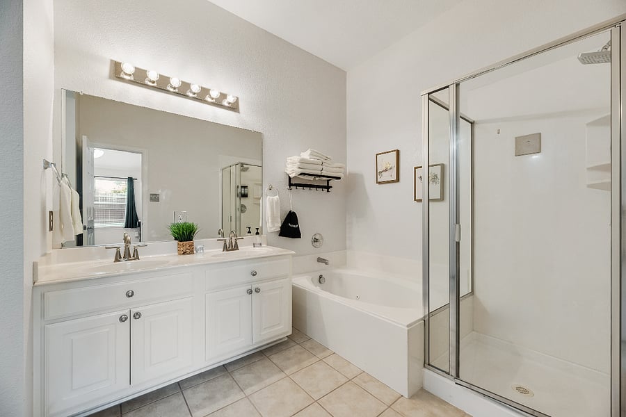 Fully stocked primary bathroom with walk-in shower, complimentary toiletries, soft towels, and hair dryer for added convenience.