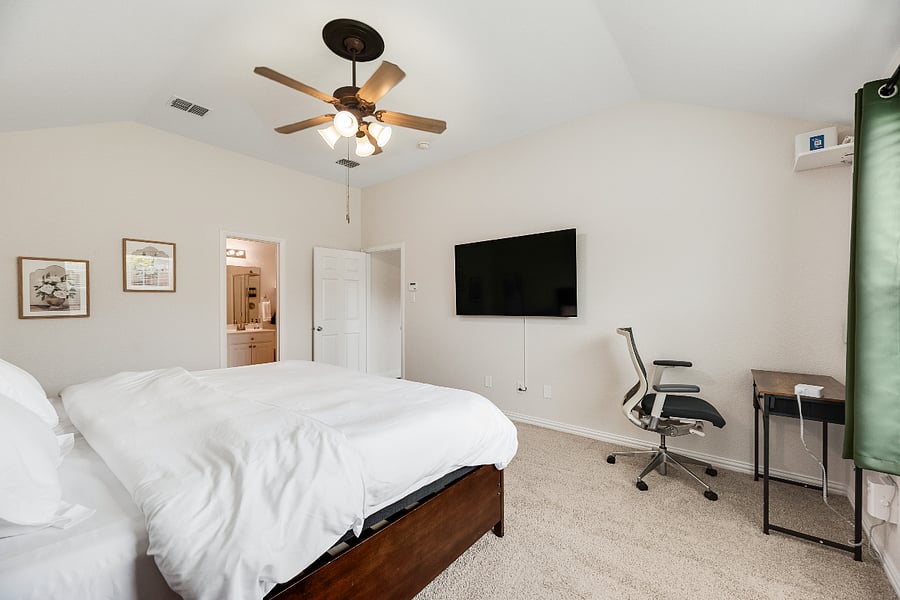 Luxury primary suite with split adjustable King bed that can sleep 2 (Zero Gravity, Head & Foot Massage with individual remotes), 65 Smart TV, and a cozy work desk designed for relaxation and productivity.