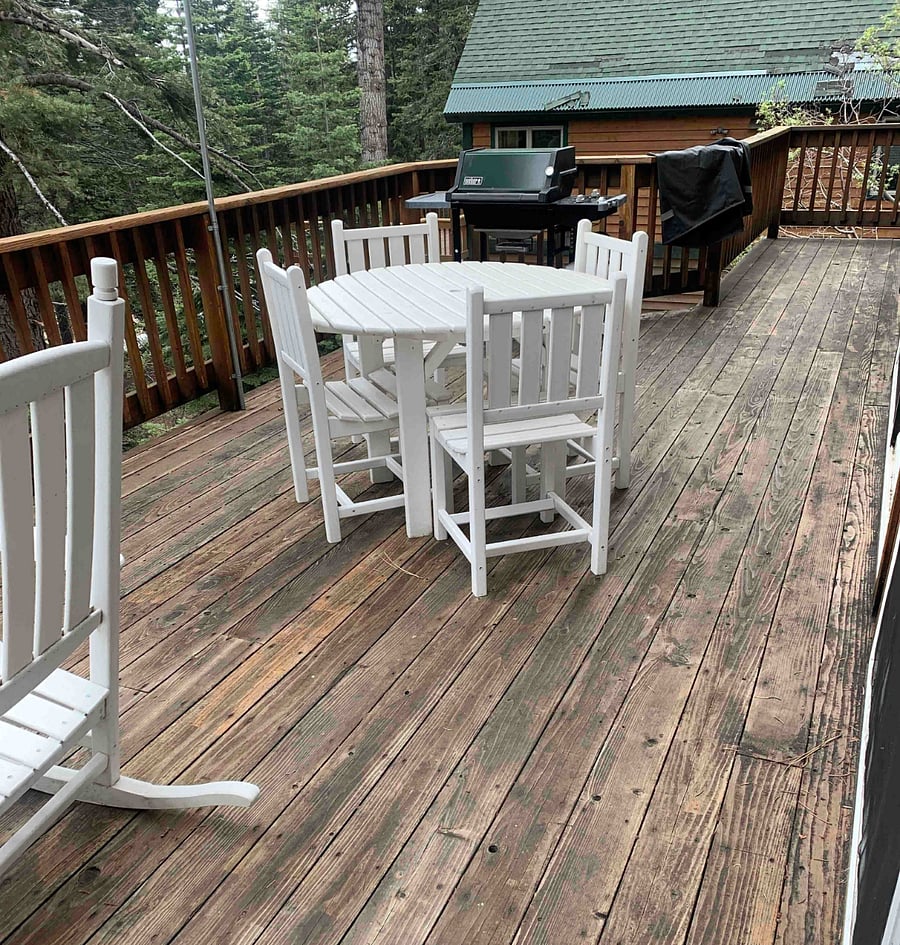 Deck with forest/mountain view. Propane BBQ with outdoor dining table, rocker, and adirondack chair.