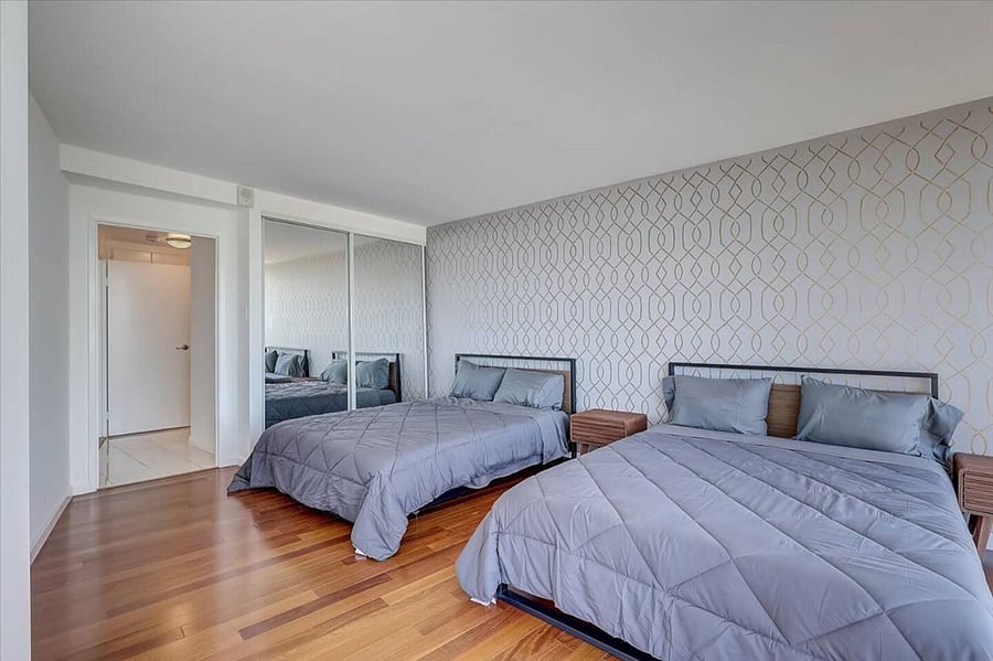2 queen beds with mirror closet. The door leads to the main restroom