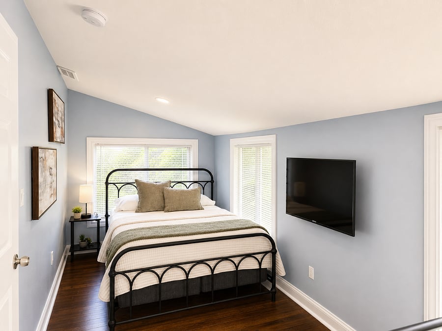 Bright and stylish bedroom with comfortable bedding, Smart TV, and plenty of natural light.