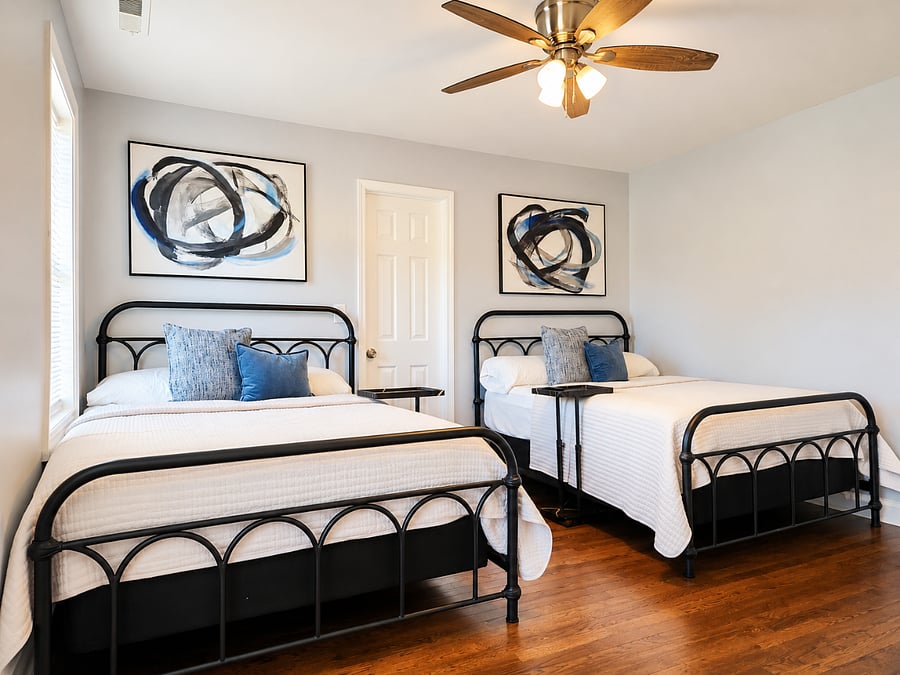 Spacious bedroom with two comfortable full beds, Smart TV, and modern finishes