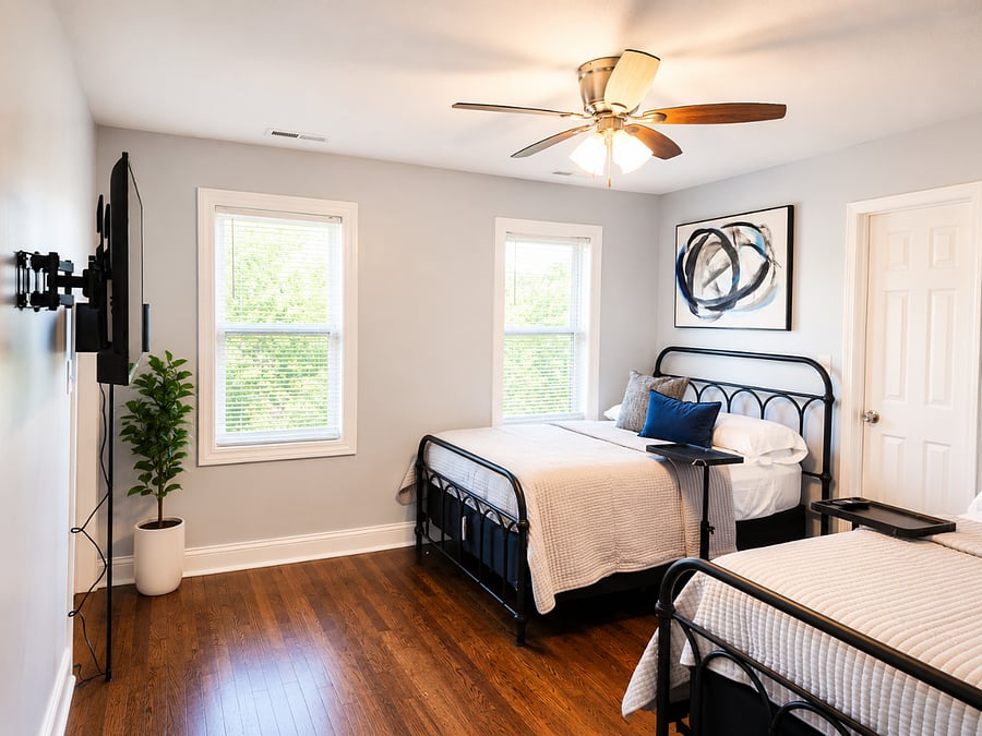 Spacious bedroom with two comfortable full beds, Smart TV, and modern finishes