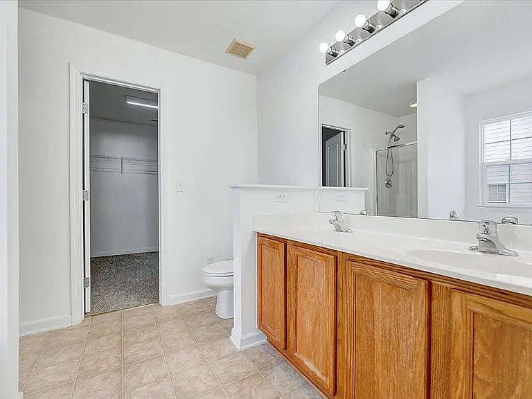 Jack n Jill bathroom with Jacuzzi and shower stall and large wall in closet 