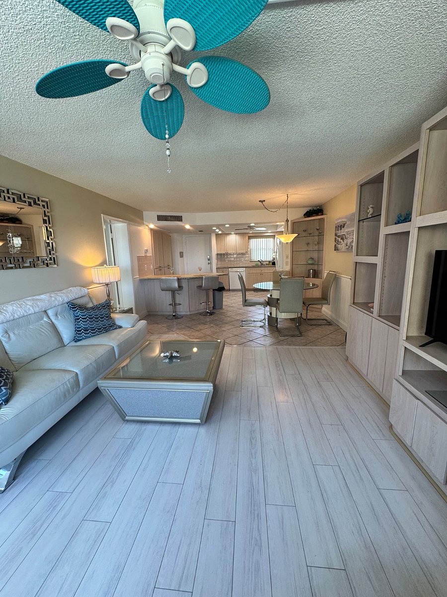 Living room with view of dining area, kitchen and front door