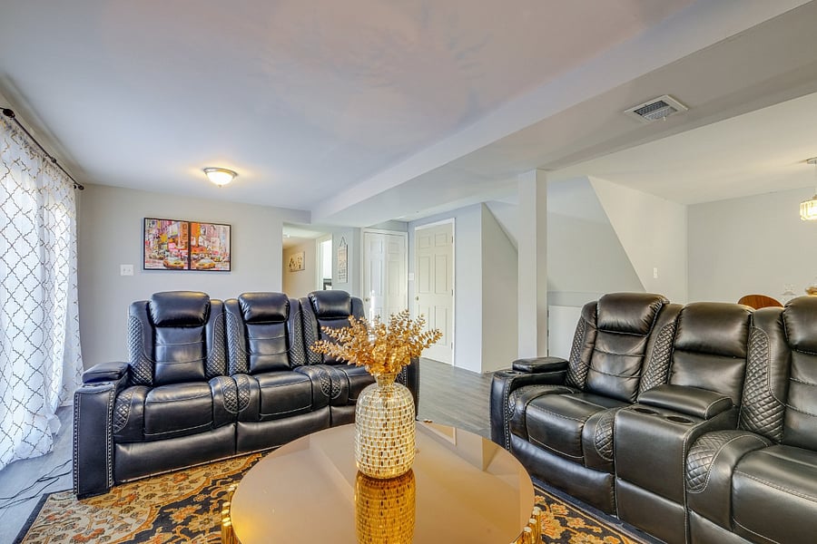 Comfortable basement living room featuring a 65 TV and reclined seating