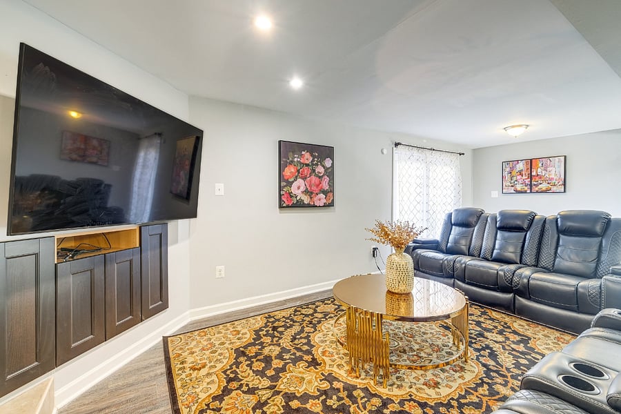 Comfortable basement living room featuring a 65 TV and reclined seating