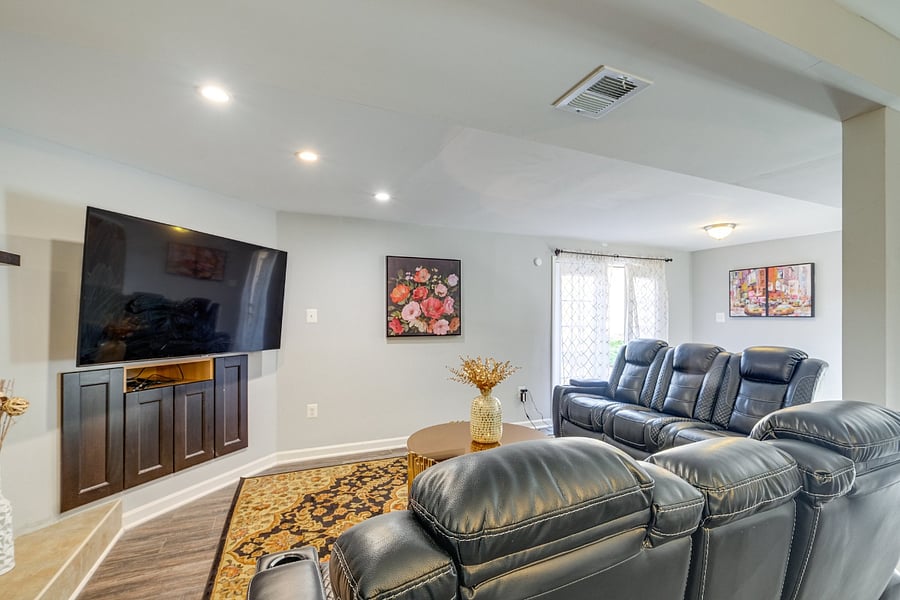 Comfortable basement living room featuring a 65 TV and reclined seating