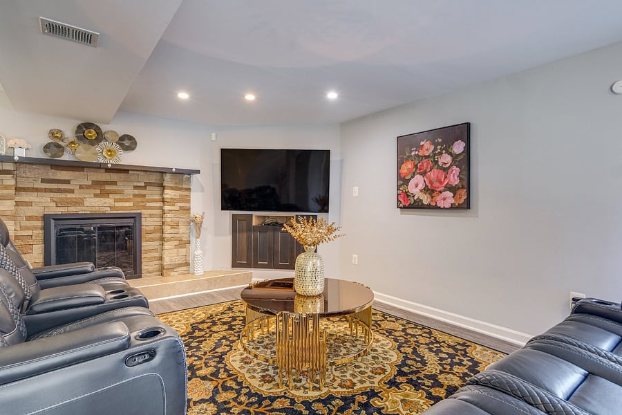 Comfortable basement living room featuring a 65 TV and reclined seating