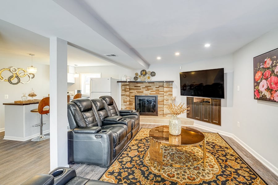 Comfortable basement living room featuring a 65 TV and reclined seating