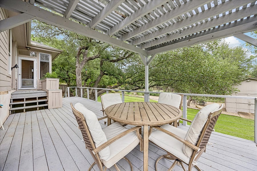 Spacious back patio overlooking the backyard and nicely shaded by the pergola