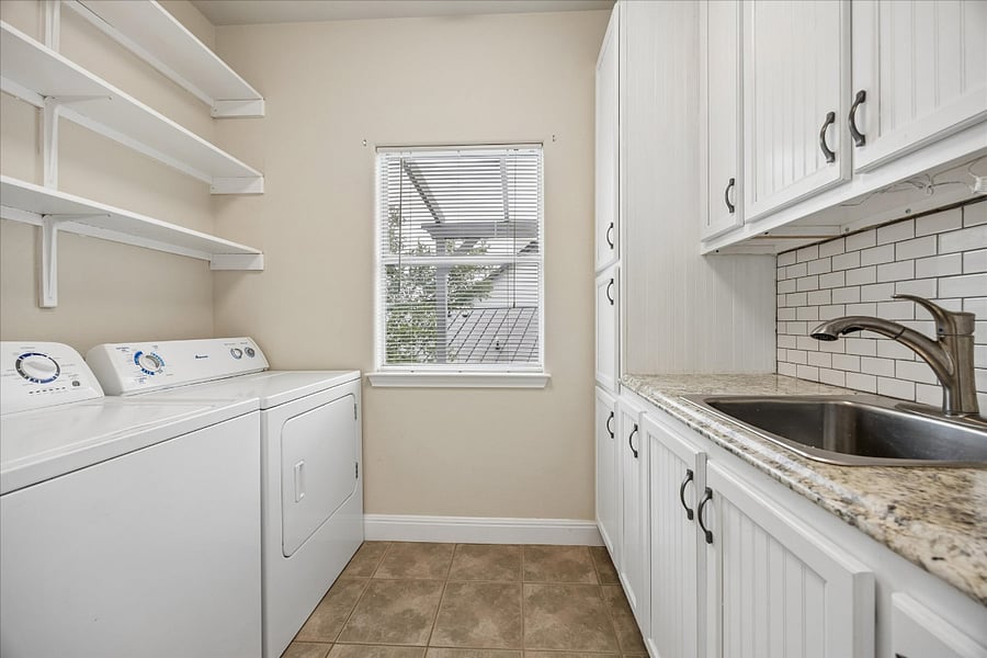 Laundry room with sink and extra cabinets for storage. 