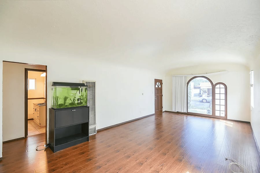 Living room with arched window and hardwood floors