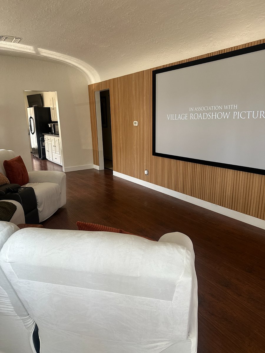 Movie nights done right  100"+ theater screen on custom wood-slat accent wall.