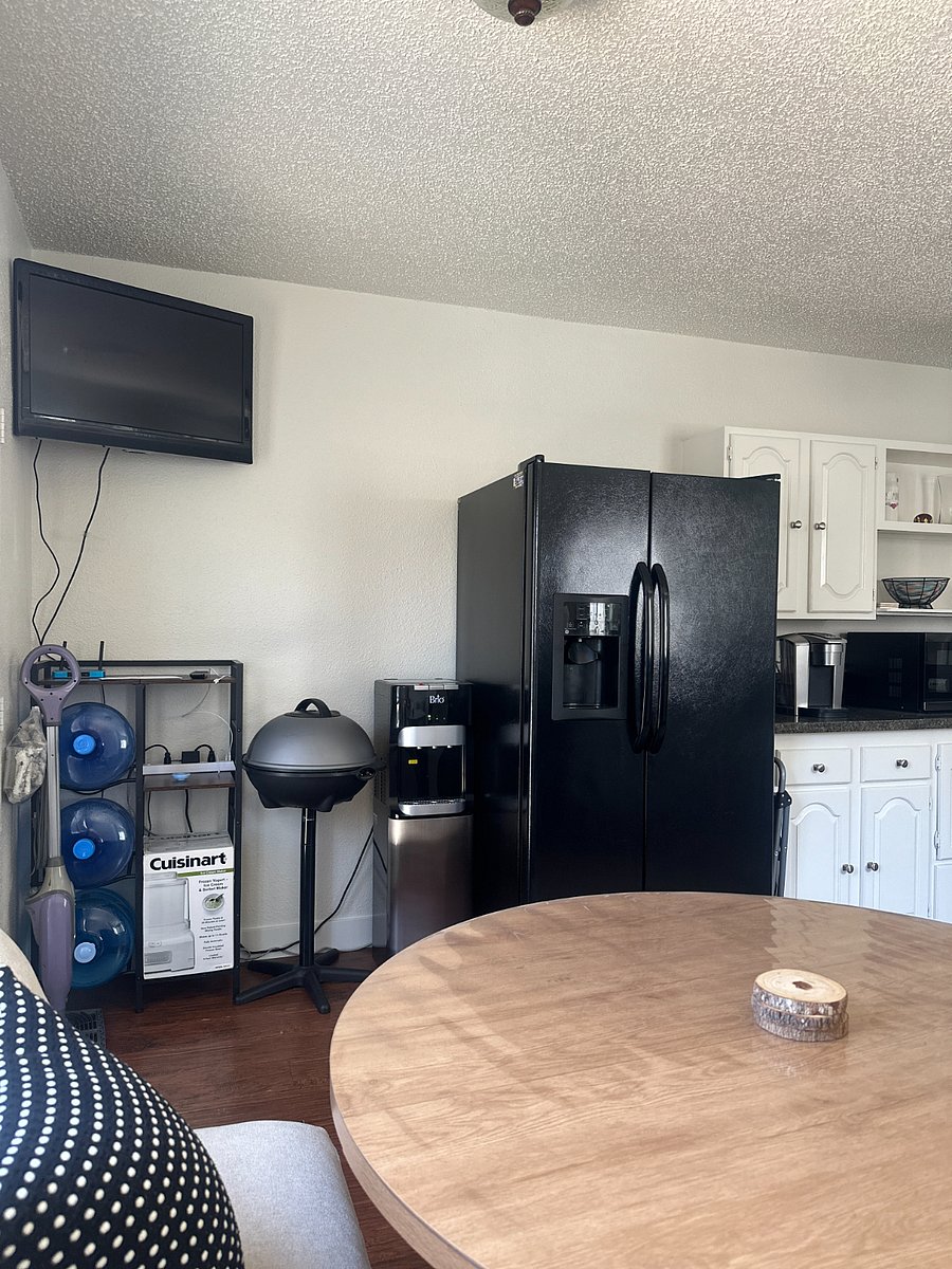 Side-by-side fridge, bottled water cooler, TV, and indoor grill.