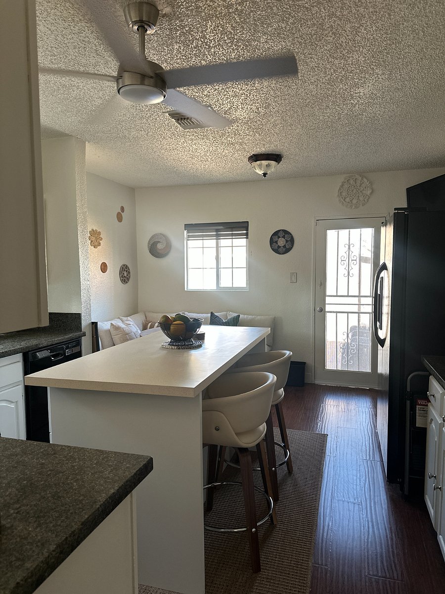 Eat-in kitchen with cozy dining nook, sectional seating, kitchen island, and backyard access. 