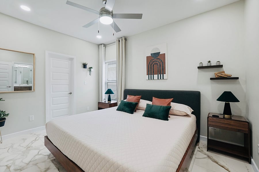 master bedroom with a king size bed, black curtains, and 43 inch smart tv