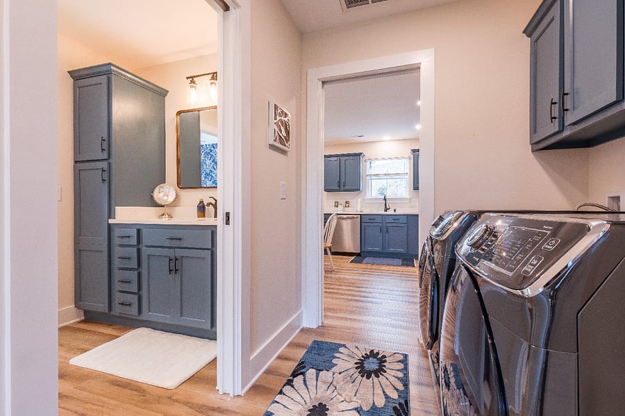 Full-sized washer and dryer, storage cabinets above.