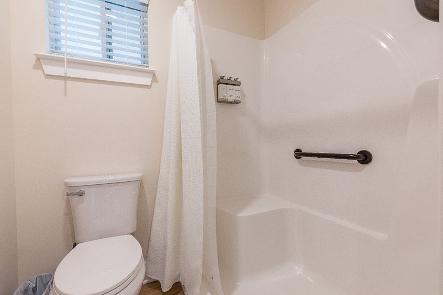 Walk in shower with grab bars and built-in seat.