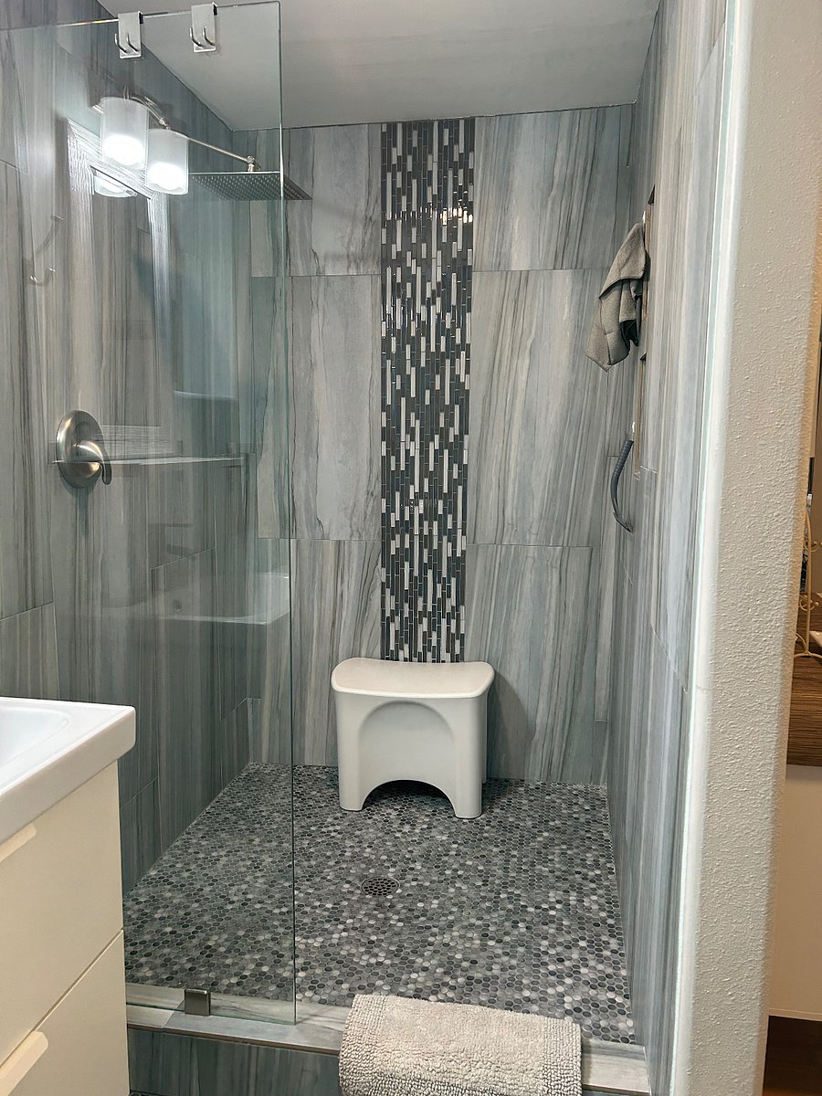 Large walk in shower with rain shower head and movable bench