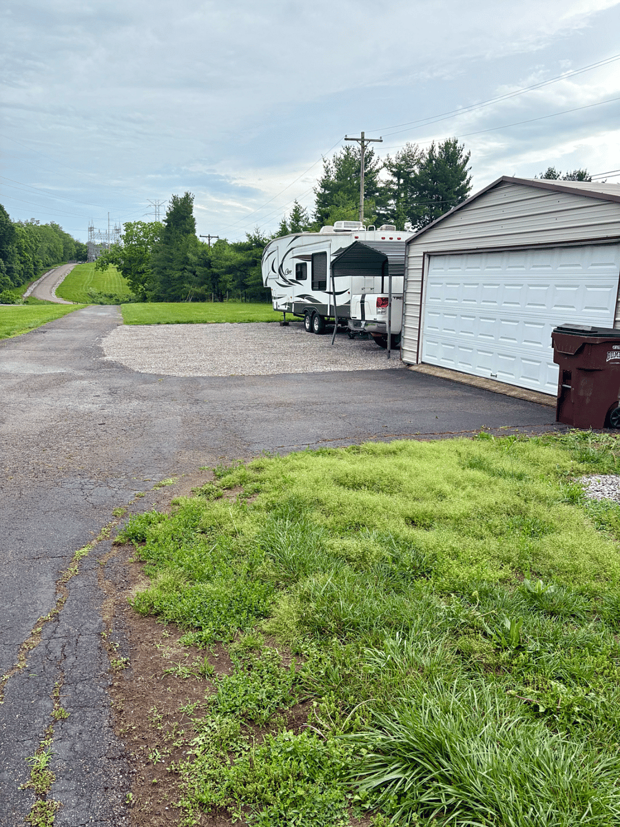 outdoor parking area infront of garage or next to 5th wheel trailer on the gravel.
