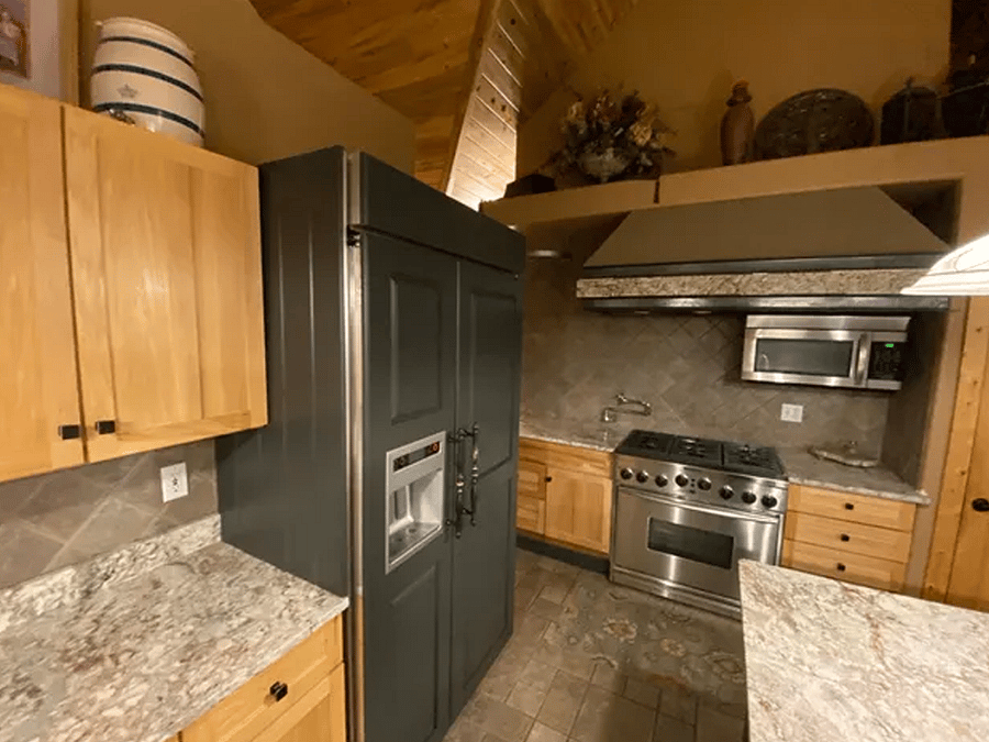 Kitchen area with full fridge, lots of cabinet space and full stove/oven