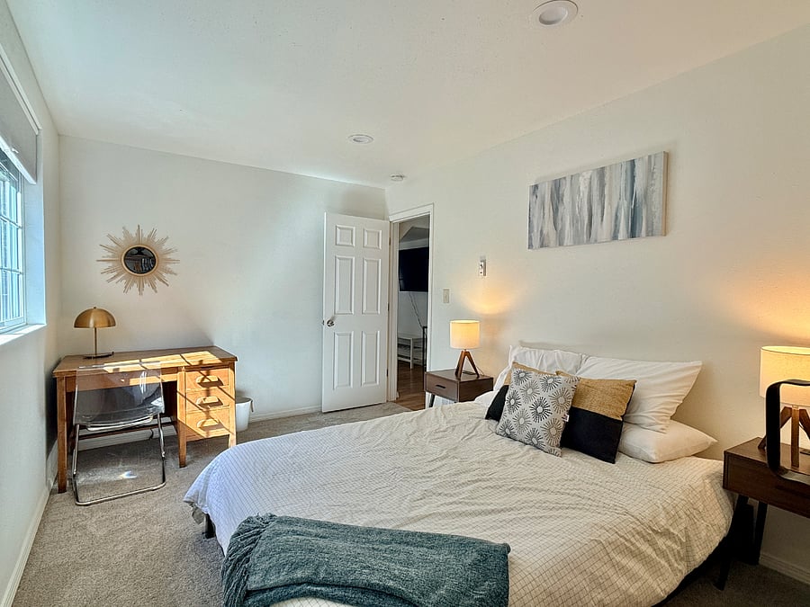 Queen primary bedroom with the best golden light streaming in the windows! Desk setup and walk-in closet with dresser. 