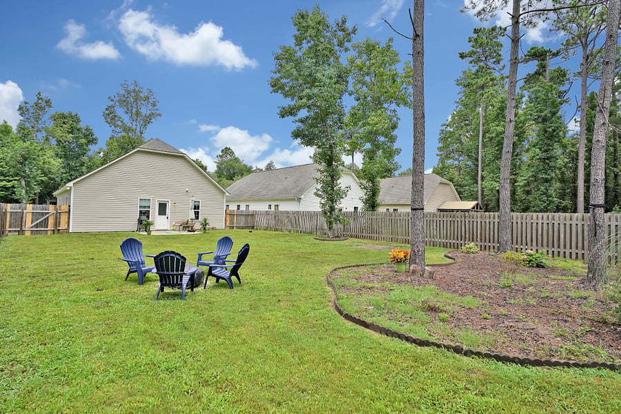 Fenced in back yard and fire pit area with landscaping
