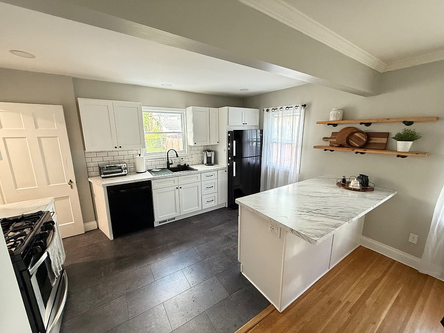 Designed for both convenience and comfort, the updated kitchen includes modern cabinetry, generous counter space, a gas stove and oven, dishwasher, microwave, toaster oven, Keurig, countertop ice maker, and a spacious island perfect for meal prep or casual dining. Fully stocked with cookware, dishes, and kitchen essentials, its ready for everything from morning coffee to family dinners. 