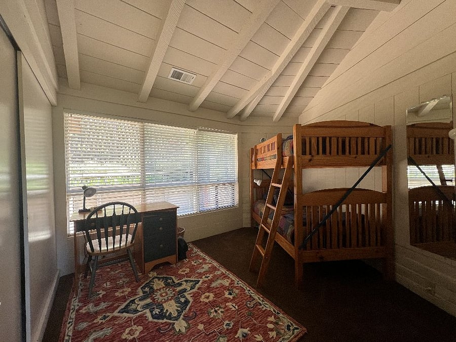 Bunk bedroom with desk and children's books.