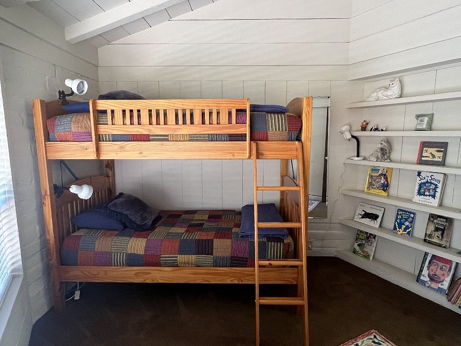 Bunk bedroom with desk and children's books.