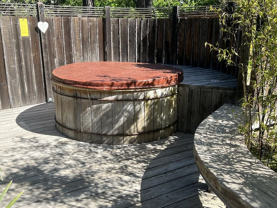 Hot tub with outdoor shower nearby.
