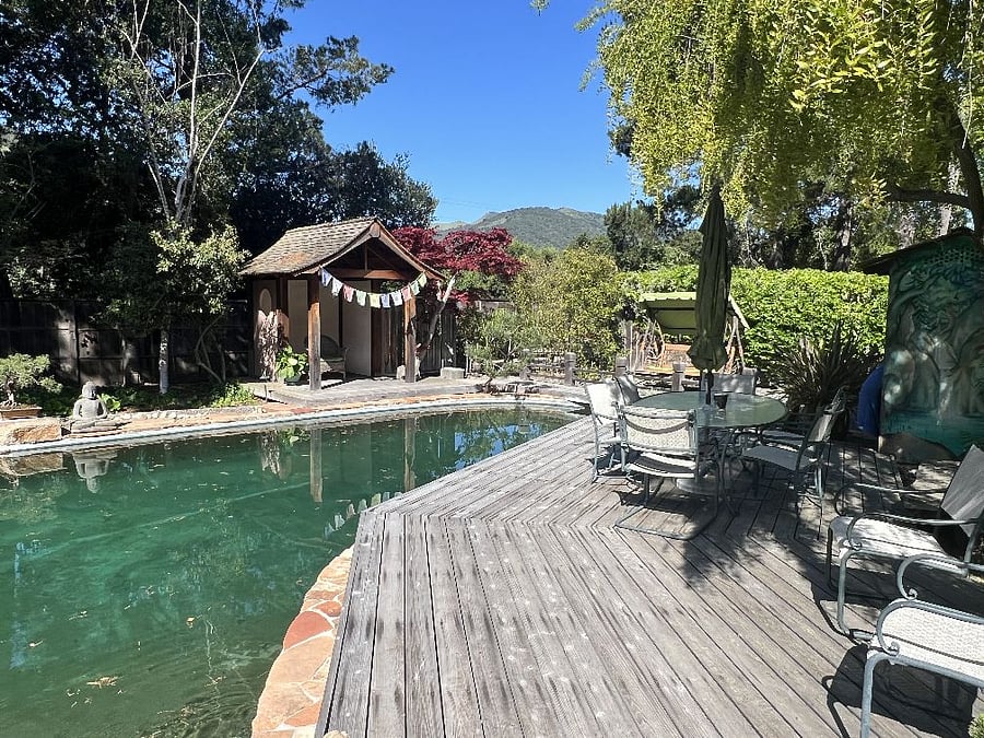 Deck by pool has large table with chairs.