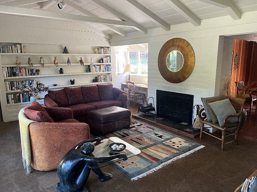 Living room with fireplace, books, and desk.