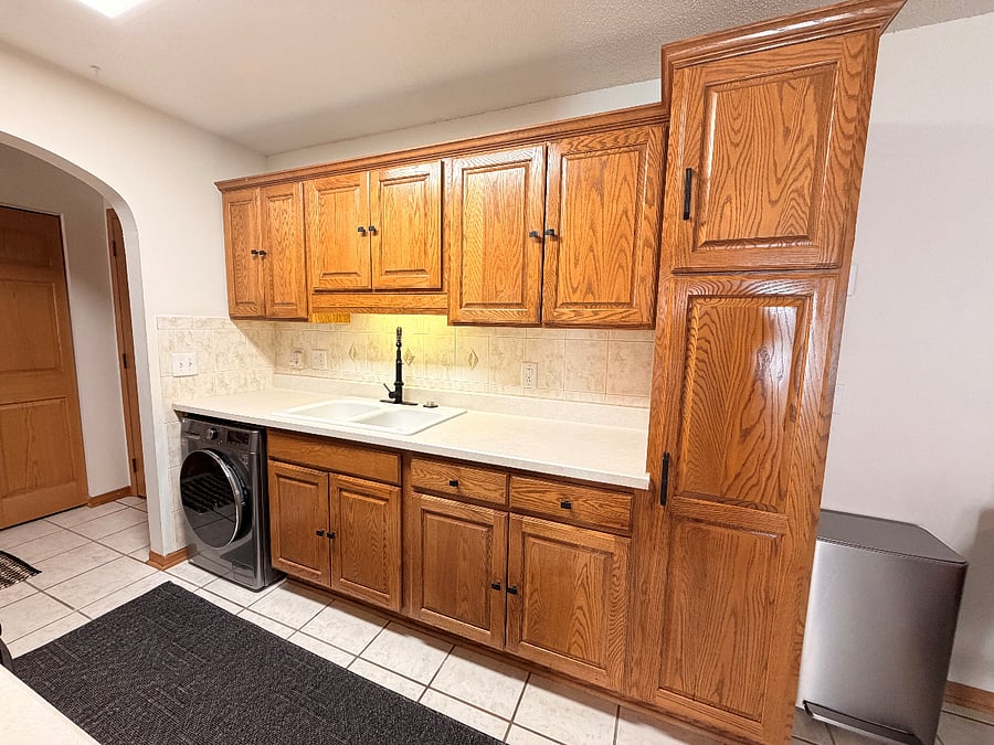 View of the sink side of the kitchen with lots of storage.