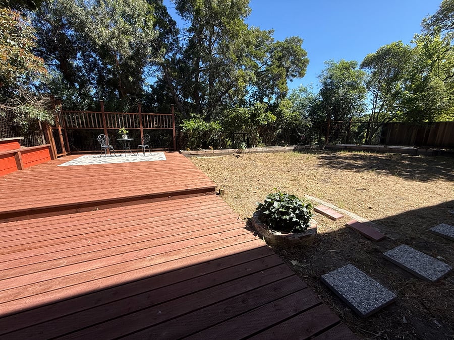 Wooden deck, fenced yard, and outdoor seating enhancce indoor-outdoor flow.