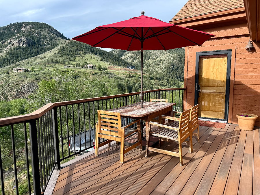 Front deck looks out across the canyon and has a table, chairs, and umbrella.