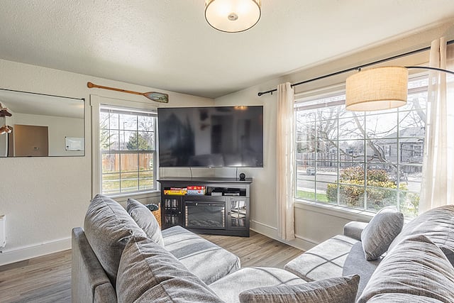 Bright living room with lots of natural light, cozy blankets, board games, and a 75" smart TV with Blu-ray player & DVDs. Perfect spot for a relaxing movie night! There are blinds on all the windows.